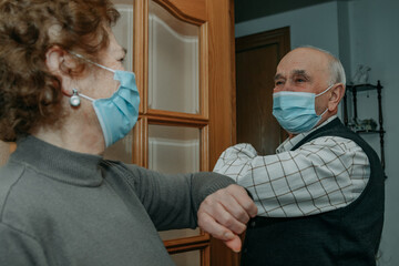 grandparents or seniors saluting each other with a mask in the coronavirus pandemic