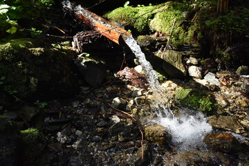 Pritschelndes Wasser, Trinkwasser an Quelle im Gebirge beim Wandern