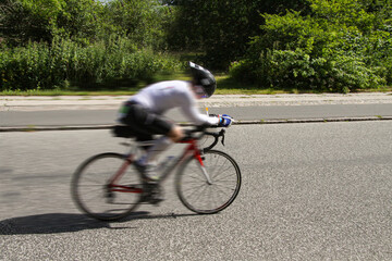 Female racing cyklist on a road bike during triathlon. Side view. Lyngby, Denmark - June 22, 2014.
