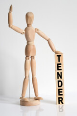 The wooden man raised his hand, and under his left hand he has cubes with the inscription - TENDER
