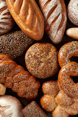 Assortment of baked goods on a dark background isometric, balance. Baked goods - golden rustic crusts of bread and buns on black chalkboard background.