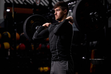 Fototapeta premium cross fit sportsman lifting barbell at gym. Man practicing functional training powerlifting workout exercises alone, in sportswear. weightlifting, bodybuilding concept