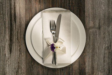 Beautiful rustic feminine wedding or  birthday  table setting.White porcelain ,cutlery,napkin and flowers..Flat lay, top view