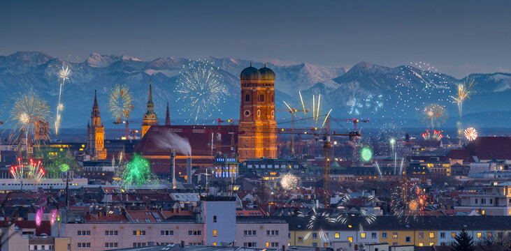 Munich at night skyline fireworks new year in background alps mountains night city light.