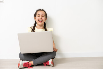 Little funny girl with laptop on white background