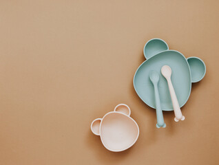 Top view neutral baby cute tableware on brown background, flat lay , copy space - 415899808