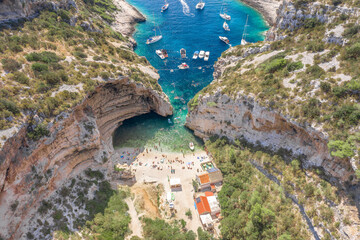 Aerial view of tourists sunbath swim at Stiniva cove beach of Adriatic sea on Vis Island in Croatia summer