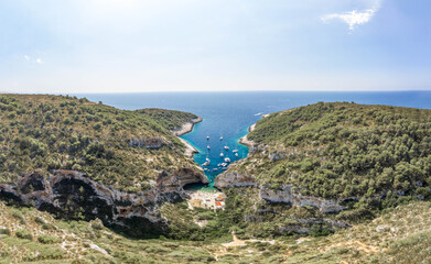 Aerial drone shot of tourists relax at Stiniva cove beach Adriatic on Vis Island in Croatia summer