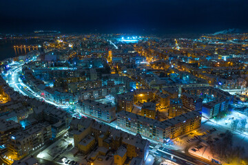 Elk city covered with snow. Night urban landscape. Aerial view.