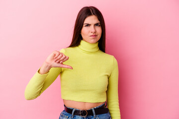 Young caucasian woman isolated on pink background showing a dislike gesture, thumbs down....