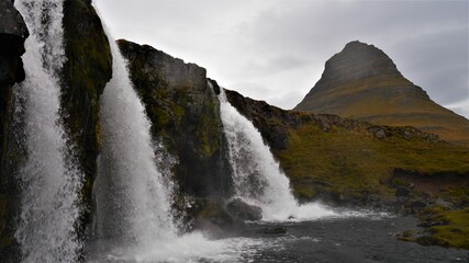 a large waterfall in front of a mountain