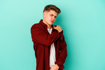 Young caucasian man isolated on blue background having a shoulder pain.