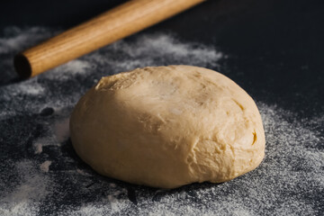 Handmade dough for bread on dark table background