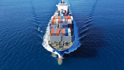 Aerial drone photo of colourful truck size container tanker ship cruising deep blue sea near...