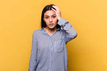 Young Indian woman isolated on yellow background being shocked, she has remembered important meeting.