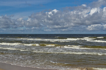 Fototapeta na wymiar Beach during the day. Clouds and sea waves.