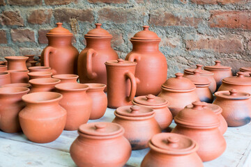 Fototapeta na wymiar Handmade clay pot, vessels, jars and cups with lides on display by a potter