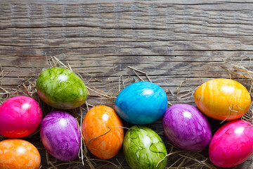 Colorful easter eggs on old wooden boards background