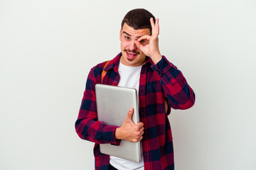 Young caucasian student man holding a laptop isolated on white background excited keeping ok gesture on eye.