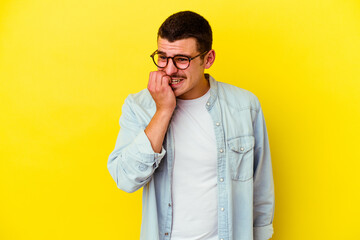 Young caucasian cool man isolated on yellow background biting fingernails, nervous and very anxious.