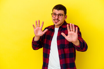Young caucasian cool man isolated on yellow background rejecting someone showing a gesture of...