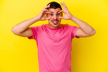 Young caucasian cool man isolated on yellow background keeping eyes opened to find a success opportunity.