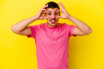 Naklejka premium Young caucasian cool man isolated on yellow background keeping eyes opened to find a success opportunity.