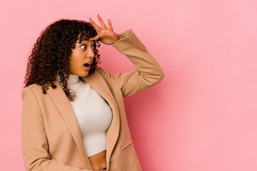 Young african american afro woman isolated looking far away keeping hand on forehead.