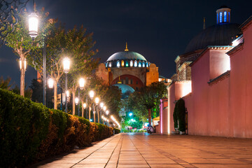 Fototapeta na wymiar The ancient Hagia Sophia, once a cathedral and an Ottoman mosque and now a museum, illuminated at night in Sultanahmet Square in Istanbul Turkey.