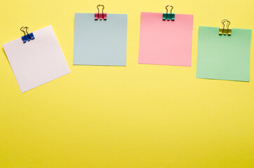Spare photo. Promotions and discounts theme.Clips with a paper card template on a yellow background for text or image. Copyspace. Paper layout. View from above