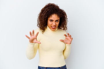 Young african american woman isolated on white background showing claws imitating a cat, aggressive gesture.