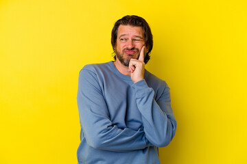 Middle age caucasian man isolated on yellow background contemplating, planning a strategy, thinking about the way of a business.