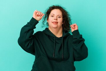 Woman with Down syndrome isolated celebrating a special day, jumps and raise arms with energy.