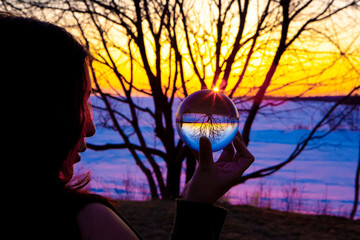 Spiritual Indian Woman seeing and watching a Crystal Lens Ball during a Colorful Sunset