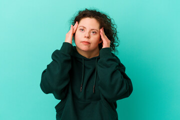 Woman with Down syndrome isolated touching temples and having headache.