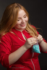 a blonde girl with an overweight plus size, in a red overall posing on a dark Studio background. holding set for Cosmetic procedure of hair removal wax,