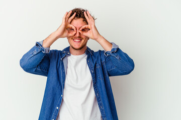 Young caucasian man isolated on white background excited keeping ok gesture on eye.