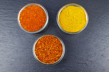 Set of different aromatic spices on black slate. Top view