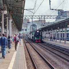 Steam retro train departs from the station.