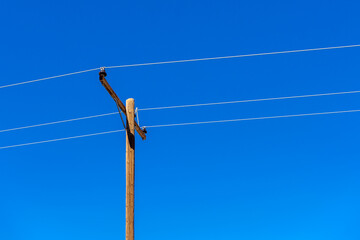 Wooden utility pole with wires and clear blue sky