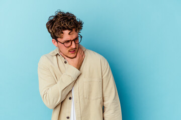 Young caucasian man wearing eyeglasses isolated on blue background suffers pain in throat due a virus or infection.