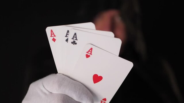 Mysterious playing poker cards in male hand with white glove