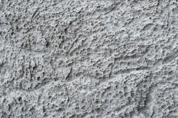 Full-screen texture of weathered and eroded gray limestone