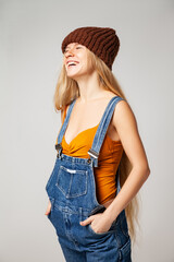 Positive hipster woman in trendy outfit against white background