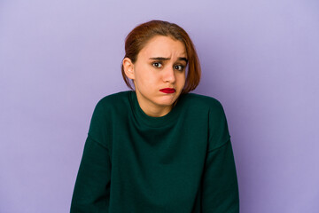 Young arab mixed race woman shrugs shoulders and open eyes confused.