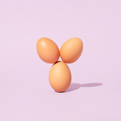 Easter eggs arranged like they have bunny ears on purple background. Minimal spring holiday concept.