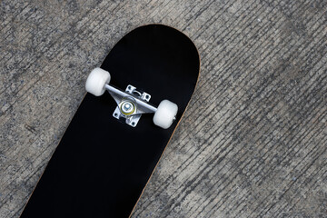 Black skateboard on cement ground. © Bowonpat