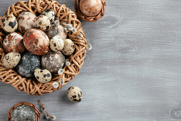 Easter composition - several marble eggs painted with natural dyes in a wicker nest and baskets, top veiw