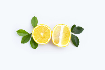 Fresh lemon with green leaves on white.