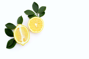 Fresh lemon with green leaves on white.